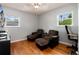 Bedroom with wood floors, a ceiling fan, two lounge chairs and two windows offering natural light at 585 Estes St, Lakewood, CO 80226