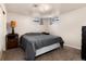 Finished bedroom with neutral carpet, a bed with gray covers, two small windows, and side tables at 585 Estes St, Lakewood, CO 80226