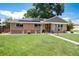 Beautiful brick house with manicured lawn, flowers, and solar panels at 585 Estes St, Lakewood, CO 80226