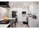Updated kitchen with stainless appliances, white cabinetry, and stylish tile flooring at 585 Estes St, Lakewood, CO 80226
