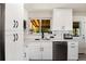 Bright kitchen features white cabinets and stainless appliances, with a view to the backyard at 585 Estes St, Lakewood, CO 80226