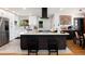 Bright eat-in kitchen with stainless appliances, white cabinets, expansive island and modern vent hood at 585 Estes St, Lakewood, CO 80226