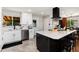 Renovated kitchen features white cabinets, stainless appliances, and center island with bar stool seating at 585 Estes St, Lakewood, CO 80226