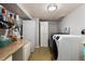 Functional laundry room with a washer, dryer, countertop, utility sink, storage cabinets, and epoxy floor at 585 Estes St, Lakewood, CO 80226
