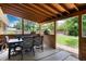 Inviting covered patio with wooden ceiling, dining set, and views of the spacious backyard at 585 Estes St, Lakewood, CO 80226