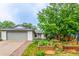 Landscaped front yard featuring garden beds and mature trees, creating a serene and inviting curb appeal at 182 Lois Cir, Louisville, CO 80027