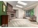 Bright living room with a stone fireplace, complemented by skylights and large windows, offering comfort and style at 182 Lois Cir, Louisville, CO 80027