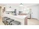 A bright open kitchen boasts a breakfast bar, white cabinets, stainless appliances, and trendy pendant lighting at 2988 S Hannibal St, Aurora, CO 80013