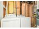 This utility room is equipped with a washer, dryer, and a modern tankless water heater at 2988 S Hannibal St, Aurora, CO 80013