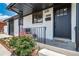 Cozy front porch with charming black door and wrought iron railings and a lovely flower garden at 7150 Beach St, Westminster, CO 80030