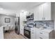 Stylish eat-in kitchen with white cabinets, stainless appliances, and a view to the kitchen table at 7150 Beach St, Westminster, CO 80030
