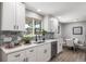 Modern, bright kitchen features white cabinets, quartz countertops, and stainless steel dishwasher at 7150 Beach St, Westminster, CO 80030