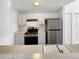 A modern kitchen with white cabinets, stainless steel appliances, and a countertop sink showcases a functional design at 6731 S Ivy Way # B4, Centennial, CO 80112