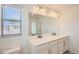 Bathroom with double vanity, large mirror, and neutral color scheme at 15243 W 69Th Ave, Arvada, CO 80007