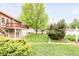 Expansive backyard featuring a lush lawn, mature trees, and a charming deck, perfect for outdoor enjoyment at 6535 Balsam St, Arvada, CO 80004