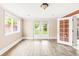 A well-lit basement room featuring laminate wood floors and glass doors leading to the backyard at 6535 Balsam St, Arvada, CO 80004