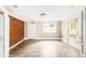 Bright basement with brick accent wall, laminated wood flooring, white trim, and access to the yard at 6535 Balsam St, Arvada, CO 80004