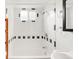 Clean bathroom featuring a white tiled tub, a shower, and a black framed mirror, designed for simplicity at 6535 Balsam St, Arvada, CO 80004