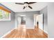 A roomy bedroom with hardwood flooring, a ceiling fan, and a large window for natural light at 6535 Balsam St, Arvada, CO 80004
