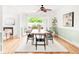 Bright dining room featuring wood floors, modern lighting, and access to outdoor deck through glass doors at 6535 Balsam St, Arvada, CO 80004