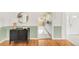 Hallway featuring hardwood floors with light-green wall trim and a kitchen view at 6535 Balsam St, Arvada, CO 80004