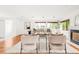 Well-lit living room with hardwood floors, a cozy fireplace, stylish seating, and views of the outdoors through large windows at 6535 Balsam St, Arvada, CO 80004