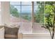 Picturesque view from the living room window showcasing rooftops and mountains in the distance, framed by lush greenery at 6535 Balsam St, Arvada, CO 80004