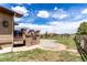Expansive backyard featuring a stone patio, lush greenery, and a rustic fence at 20097 Royal Troon Dr, Monument, CO 80132