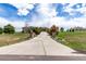 Long driveway leading up to a gorgeous home surrounded by lush greenery and mature trees at 20097 Royal Troon Dr, Monument, CO 80132