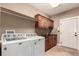 Convenient laundry room equipped with washer, dryer, sink, and ample cabinet space at 20097 Royal Troon Dr, Monument, CO 80132