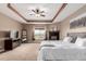 Comfortable main bedroom featuring neutral walls, carpet and tray ceiling with fan at 20097 Royal Troon Dr, Monument, CO 80132