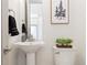 Cozy powder room features pedestal sink, modern fixtures, and charming decor at 2409 Court Pl, Denver, CO 80205