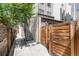 Side view of modern townhome with wooden privacy gate, brick accents, and convenient walkway at 2409 Court Pl, Denver, CO 80205