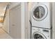 Convenient laundry area featuring a stacked washer and dryer with staircase access nearby at 2409 Court Pl, Denver, CO 80205