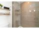 Modern shower with light gray tiling and shelves, and glass door enclosure at 2409 Court Pl, Denver, CO 80205