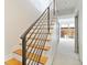 Contemporary staircase featuring wood treads, metal railing, and views of the outdoor patio at 2409 Court Pl, Denver, CO 80205