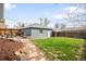 Serene backyard featuring a well-maintained lawn, stone pathway, and mature trees, perfect for outdoor enjoyment at 4824 Knox Ct, Denver, CO 80221