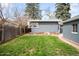 Lush backyard with green lawn, mature trees, and a patio area, ideal for outdoor activities and relaxation at 4824 Knox Ct, Denver, CO 80221