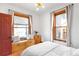 Sunlit bedroom with large windows, built-in bench, and hardwood floors at 4824 Knox Ct, Denver, CO 80221