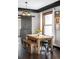 Bright dining room featuring a wooden table with a bench, a sliding barn door, and natural light from the window at 4824 Knox Ct, Denver, CO 80221