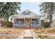 Charming gray home with a landscaped front yard, covered porch, and inviting walkway at 4824 Knox Ct, Denver, CO 80221