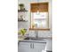 Close up of kitchen sink with white cabinets, light countertops, stainless steel faucet, and bamboo blind at 4824 Knox Ct, Denver, CO 80221