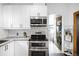 Modern kitchen with white cabinets, stainless steel appliances, and subway tile backsplash at 4824 Knox Ct, Denver, CO 80221