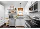 Modern kitchen with white cabinets, stainless steel appliances, light countertops, and floating shelves at 4824 Knox Ct, Denver, CO 80221