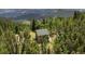 Aerial view of home surrounded by dense forest; tranquil and secluded location at 1555 Three Peaks Rd, Golden, CO 80403