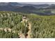 Remote mountain home nestled in lush green forest; aerial shot at 1555 Three Peaks Rd, Golden, CO 80403