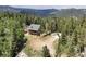 Aerial view of mountain home surrounded by forest; large lot at 1555 Three Peaks Rd, Golden, CO 80403