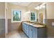 Bright bathroom with double sink vanity, granite counters, and views of the surrounding trees at 1555 Three Peaks Rd, Golden, CO 80403