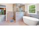 Bathroom featuring a stone-tiled walk-in shower and free-standing tub next to a large window at 1555 Three Peaks Rd, Golden, CO 80403