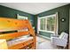 Cozy bedroom featuring a wooden bunk bed, chair, and large windows offering lovely views of the surrounding forest at 1555 Three Peaks Rd, Golden, CO 80403